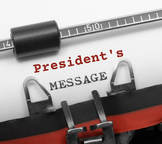 Paper in an old fashioned typewriter with a black & red ribbon with the words, "President's Message."