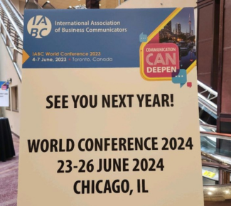 Cardboard sign on an easel in a hotel reading, "See You Next Year! World Conference 2024 23-26 June 2024, Chicago, IL"